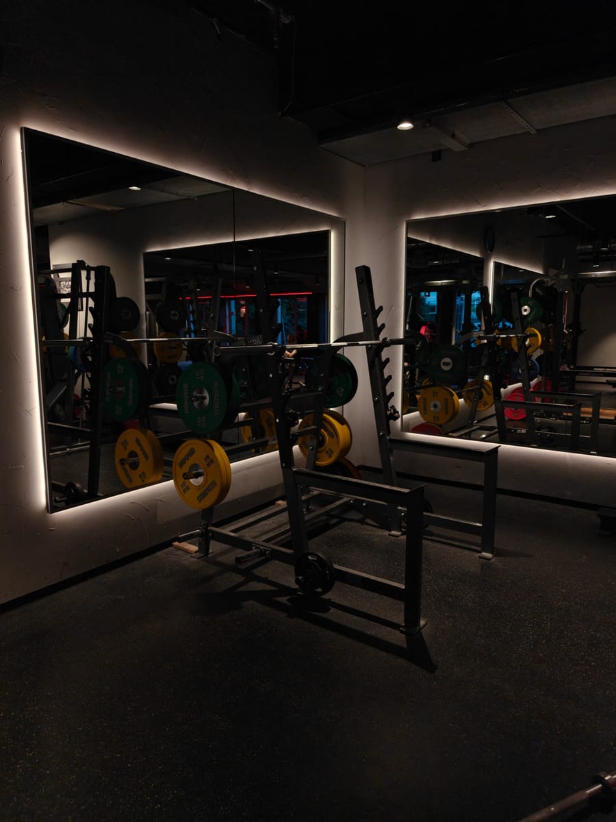 Hantelbereich mit Racks und Spiegeln in einem Wellpass-Studio